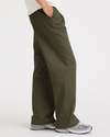 Side view of model wearing Army Green Original Khakis, Pleated, High Wide Fit.