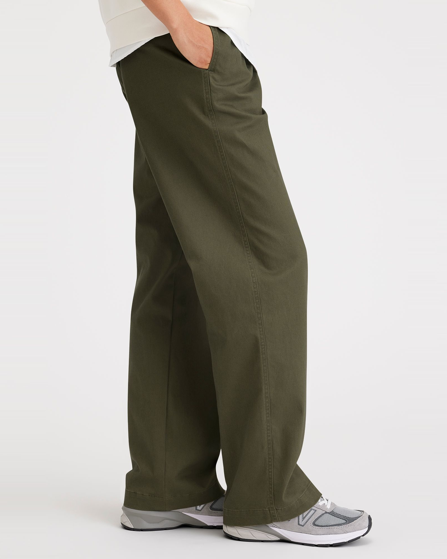 Side view of model wearing Army Green Original Khakis, Pleated, High Wide Fit.