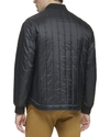 Back view of model wearing Black Recycled Nylon Channel Quilted Bomber Jacket.
