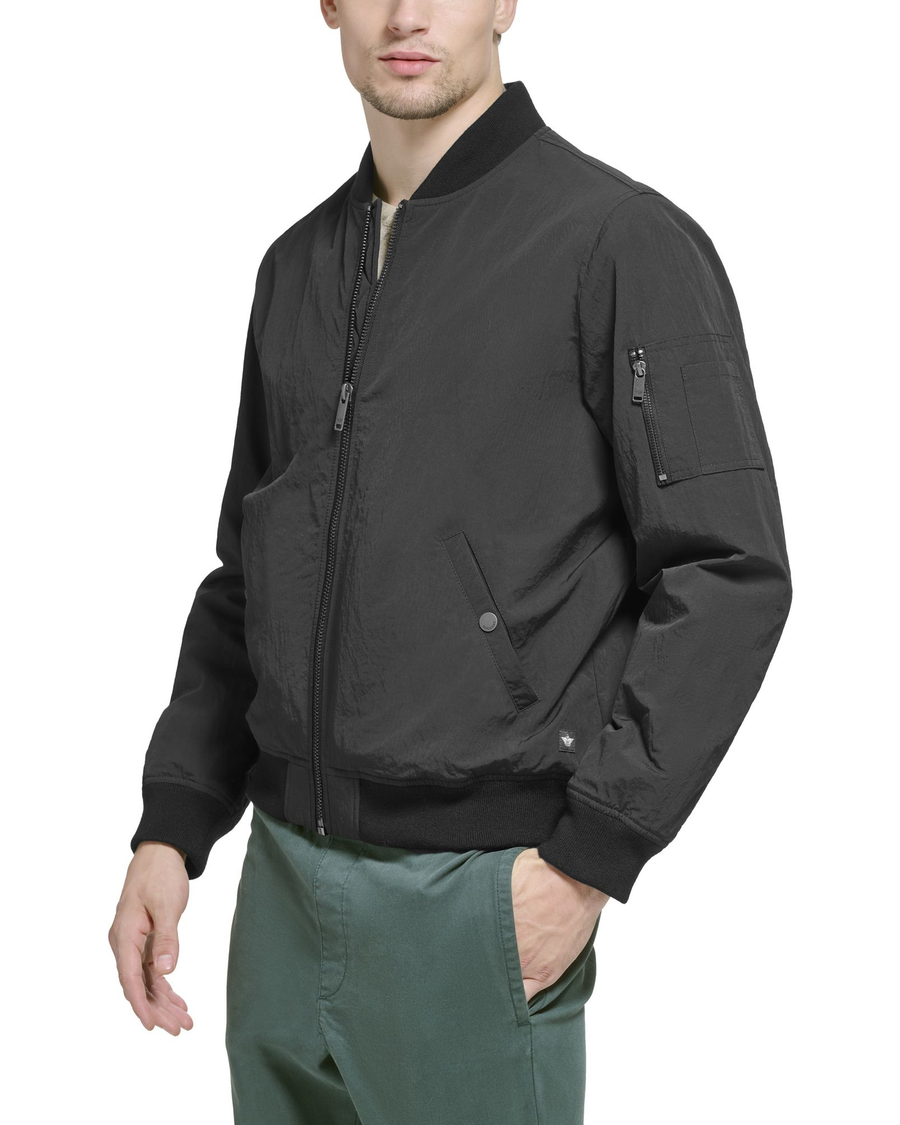 Side view of model wearing Black Recycled Sail Nylon Bomber Jacket.
