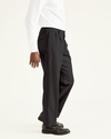 Side view of model wearing Black Signature Khakis, Pleated, Classic Fit.