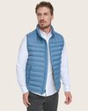 View of model wearing Blue Packable Puffer Vest.