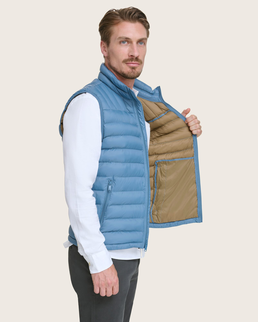 View of model wearing Blue Packable Puffer Vest.