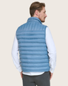 Back view of model wearing Blue Packable Puffer Vest.