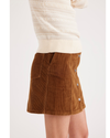 Side view of model wearing Caramel Cafe Button Front Mini Skirt.