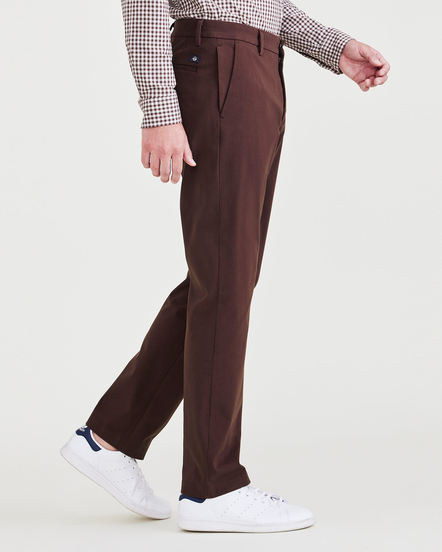 Side view of model wearing Decadent Chocolate City Tech Trousers, Slim Fit.