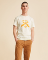 Front view of model wearing Egret & Gold Waves for Water Graphic Tee, Slim Fit.