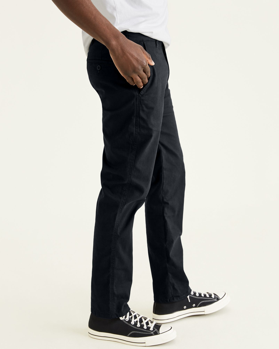 Side view of model wearing Mineral Black Original Chinos, Straight Tapered Fit.