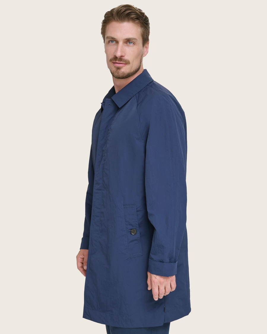 Side view of model wearing Navy Sail Cloth Trench Coat.
