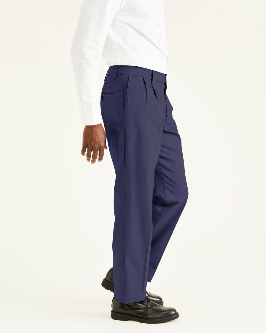 Side view of model wearing Navy Signature Khakis, Pleated, Classic Fit.