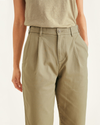 View of model wearing New British Khaki Original Khakis, Pleated, High Waisted Tapered Fit.