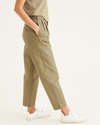Side view of model wearing New British Khaki Original Khakis, Pleated, High Waisted Tapered Fit.