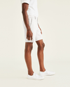 Side view of model wearing Paper White Ultimate 9.5" Shorts, Straight Fit.